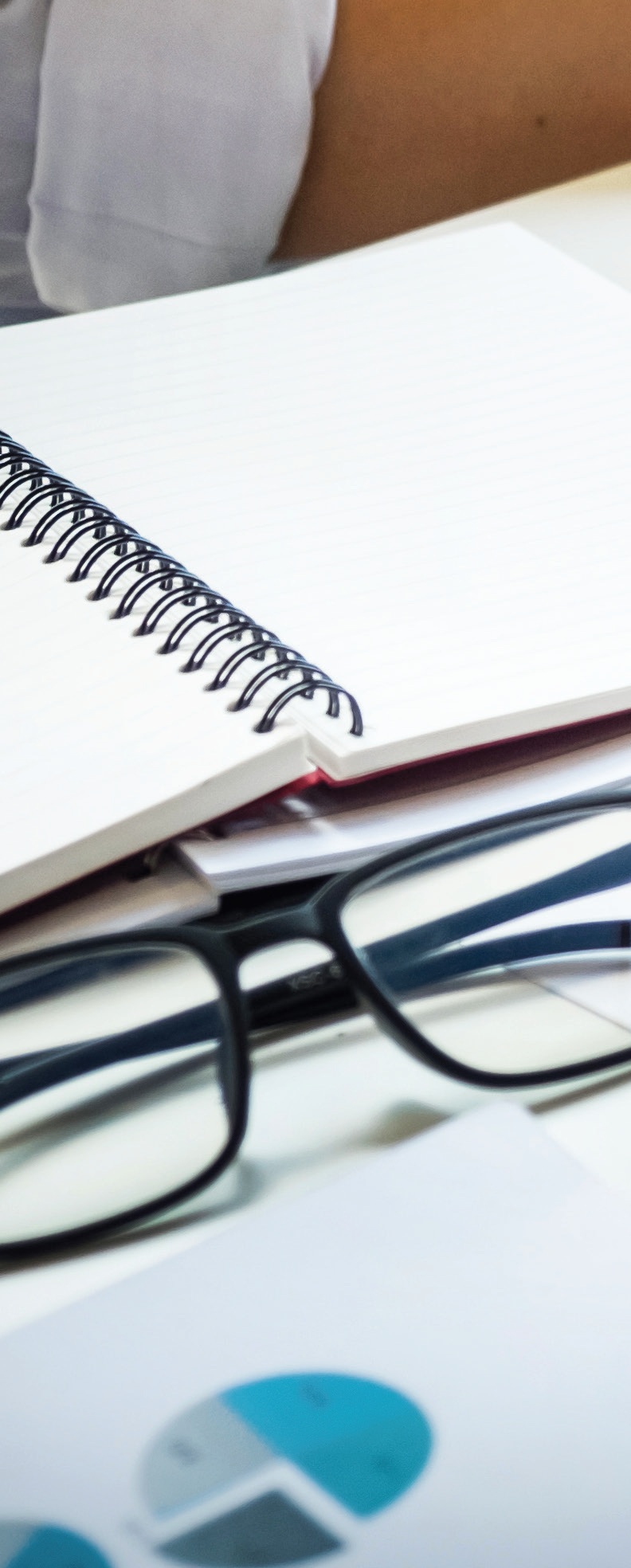 Decorative image of glasses in front of a notebook